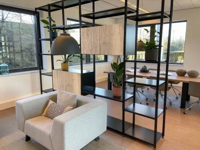 Industriële roomdivider in zwart met open planken, houten accenten en decoratieve planten voor een modern interieur.