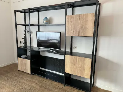 Zwarte stellingkast toegepast als TV kast met eik natuur deurensets en brede legborden voor de TV.