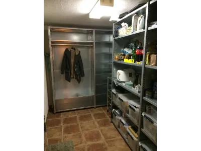 inloopkast van stellingkasten die gecombineerd garderobe en algemene opslag opbergen.