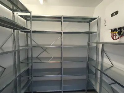 Compact metalen opbergrek met smalle afmetingen, geschikt voor kleine ruimtes zoals een voorraadkast of washok.