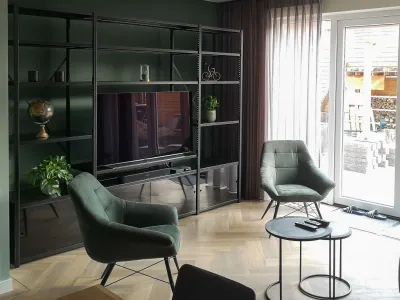 Zwarte wandkast als TV meubel met zwarte schuifdeuren onderin.