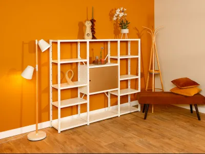 Wit ge-poedercoate wandkast steekt mooi af tegen fel gekleurde muur in moderne woonkamer.