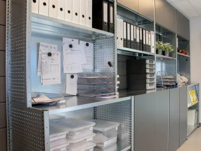 Kantoorkast van stalen stellingkast met verspringing in de diepte voor opslag van kantoormaterialen.