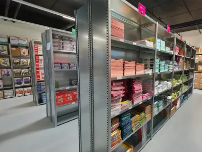 Smalle opbergrekken met de ruggen tegen elkaar gemonteerd voor opslag van archief en kantoormaterialen.
