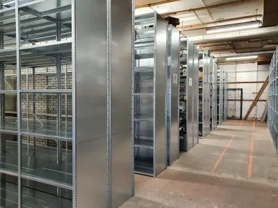 Stellingkast toegepast in een magazijn met veel legborden in de hoogte opgesteld in rijen met looppaden voor efficiënte opslag v