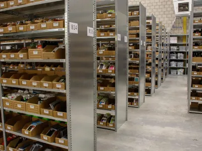 Magazijnstellingen met veel legborden boven elkaar voor de opslag van kleine materialen in groot magazijn.