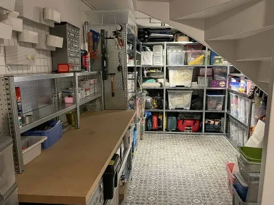 Kelder optimaal ingericht met stellingkasten op maat en werkbank.