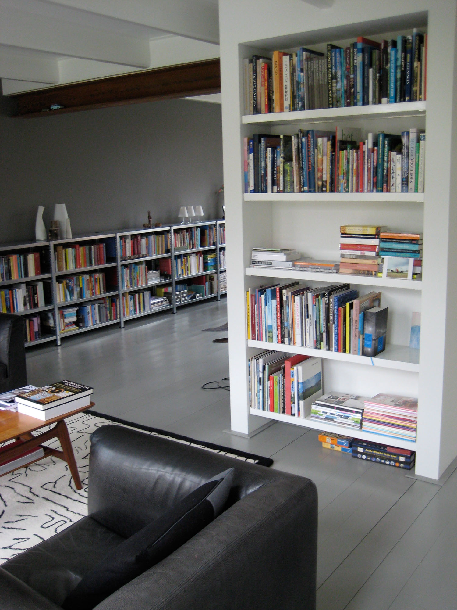 Combinatie van warme materialen en stalen boekenkast in woonkamer
