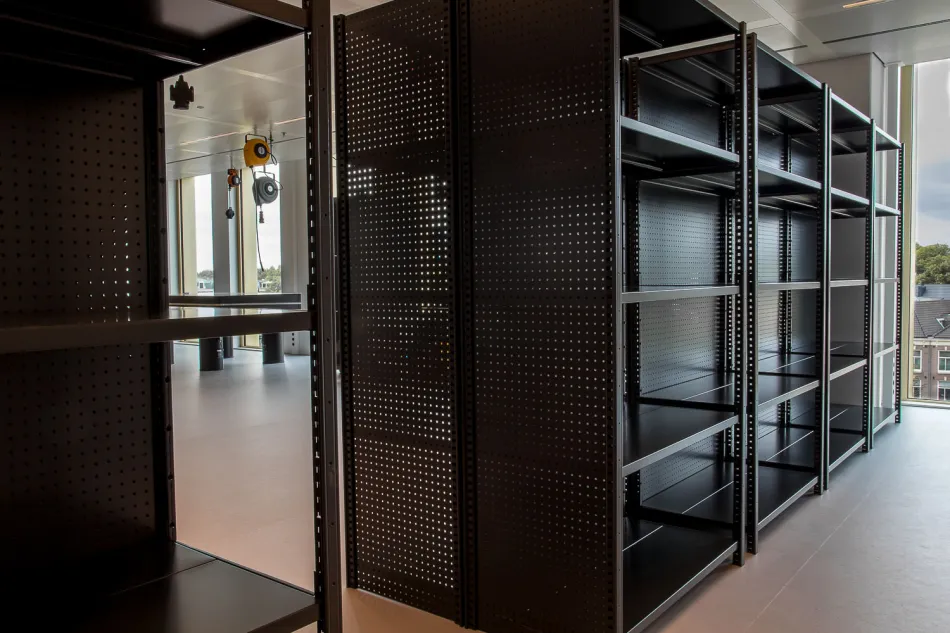 Dubbele rij zwarte stellingkast met perfo zijwanden. 