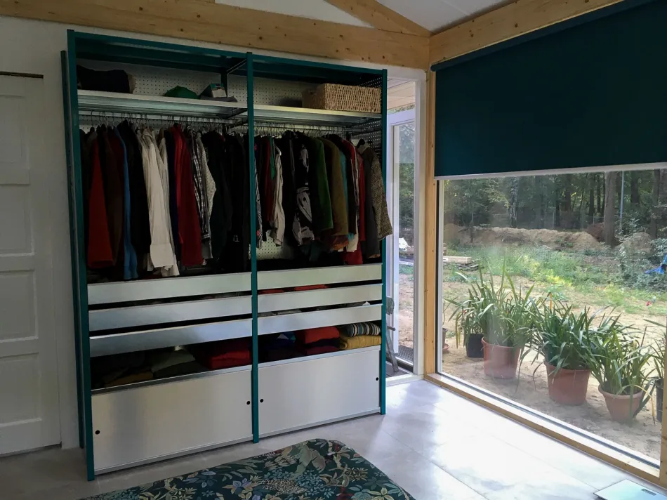 Garderobekast met groene staanders en metalen lades.