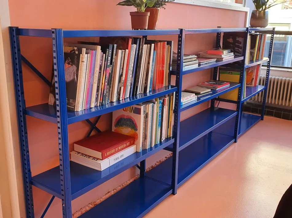 Blauwe lage stellingkast met blauwe plangen voor opslag van o.a. boeken. 