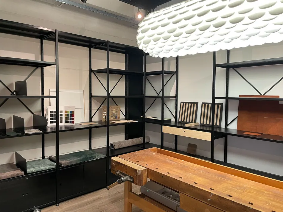 Industrieel ingerichte ruimte met zwarte metalen stellingkasten en houten werktafel.