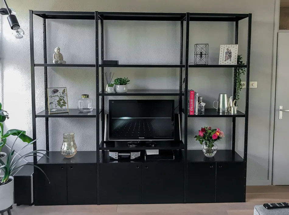 Open zwarte stellingkast met brede opening voor TV en zwarte schuifdeursets.