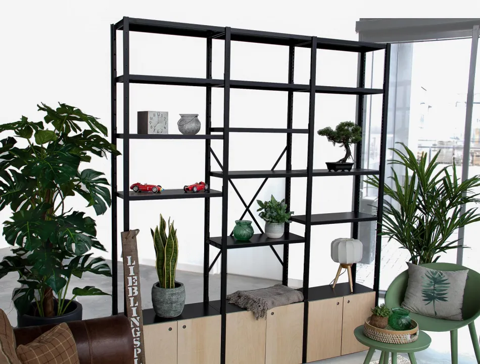 Zwarte metalen stellingkast met geïntegreerde planten en houten panelen in een open werkruimte.