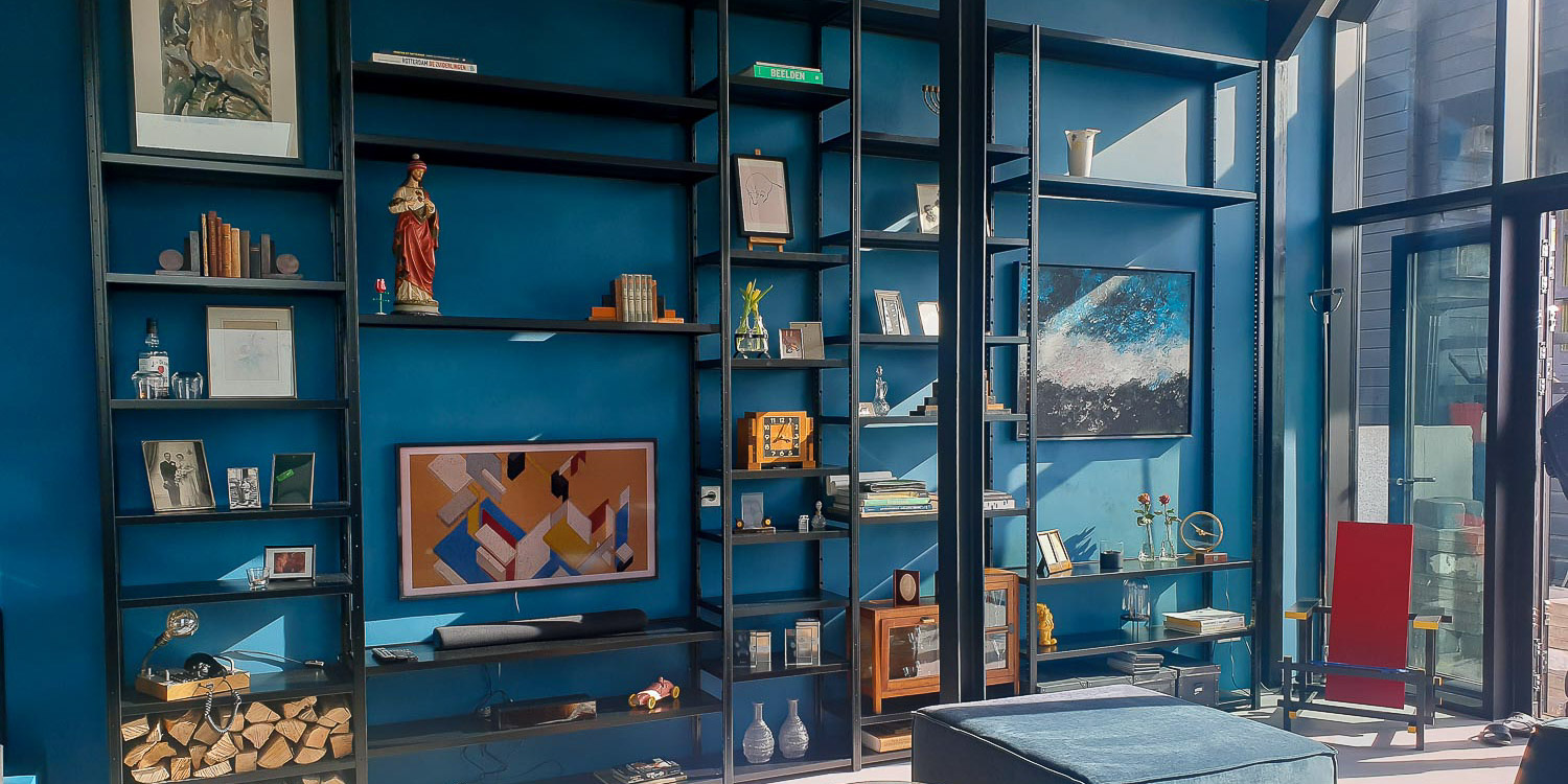 Zwarte stellingkast met korte en lange legborden en open uitstraling voor decoratie.